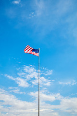 American flag in the blue sky on a sunny day.