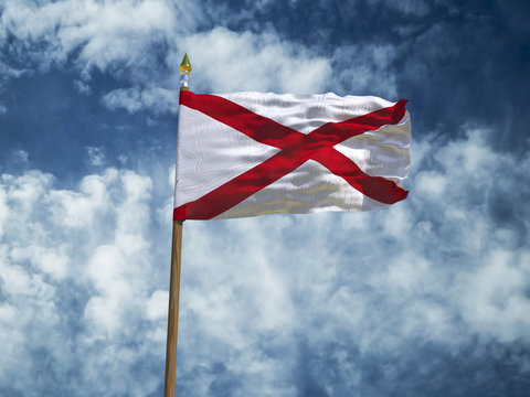 Alabama flag USA flag Silk waving flag made transparent fabric of Alabama US state with wooden flagpole gold spear on background sunny blue sky white smoke clouds real retro photo 3d illustration