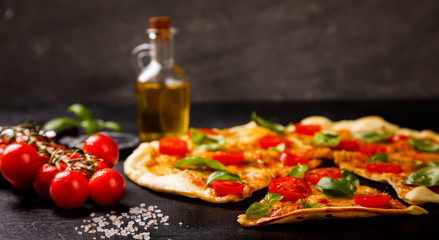 Pizza Margarita with Mozzarella and Basil on the Black Background Bake Snack with Tomatoes