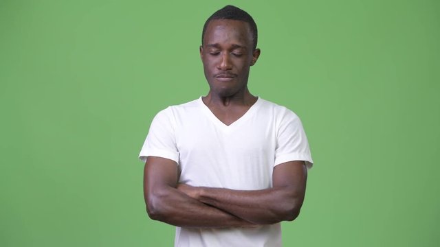 Young African man looking angry with arms crossed and eyes closed