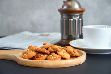 Morning meal cookies on wood plate with coffee cup on the table