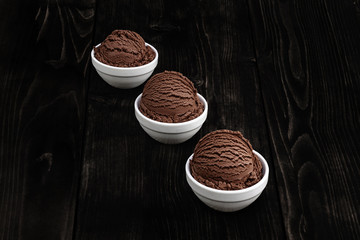 Chocolate ice cream with bowl on wooden background