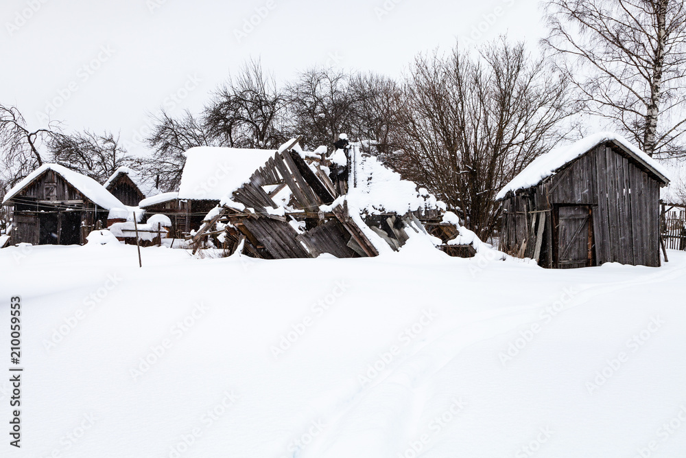 Sticker snow-covered old abandoned courtyard in village