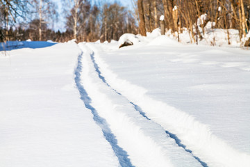 Fototapeta na wymiar ski track on snow field in sunny winter day