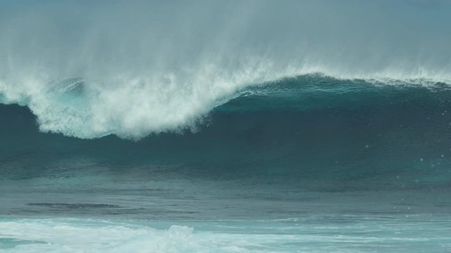 SLOW MOTION, CLOSE UP: Breathtaking blue barrel wave crashing towards the exotic island shore on a sunny day. Cinematic shot of beautiful crystal clear tube wave rushing towards the remote beach.