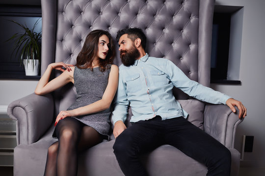 Couple in struggle or conflict, sad and distant with cold looks on their faces.Problems in relationship, breakup concept.Beautiful loving couple sitting together on the couch and looking at each other
