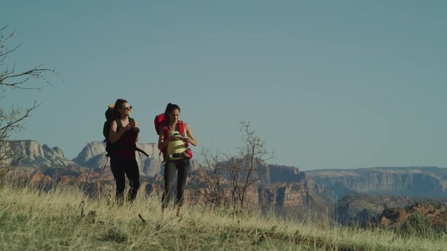 Slow motion panning shot of backpacking woman photographing scenic view / Virgin, Utah, United States