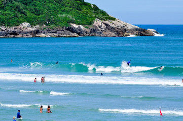 Surfing on the blue sea with green island background