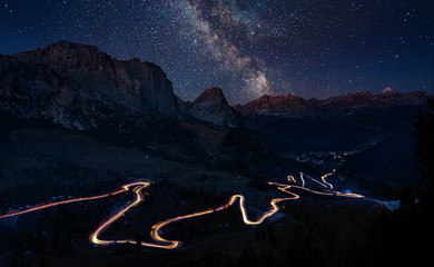 Traffic trails on mountain pass at night with milkyway - obrazy, fototapety, plakaty