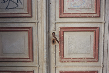 Eine alte verwitterte weiße Tür mit roten Applikationen in Stralsund 