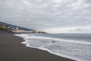 Puerto de la Cruz, Tenerife, Canary Islands - view of colorful houses, sea and volcanic-sand beach. Black beach in tenerife