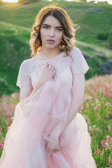 Happy bride in a pink dress, in the hands of a bouquet of peonies