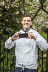 Парень фотографирует на черный телефон