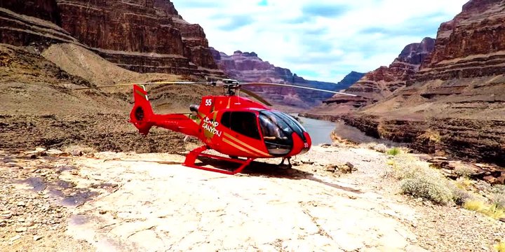 Model walking around a helicopter in the middle of the Grand Canyon