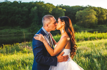 portrait of the bride and groom in nature on a sunny day, a couple in love is kissing in nature