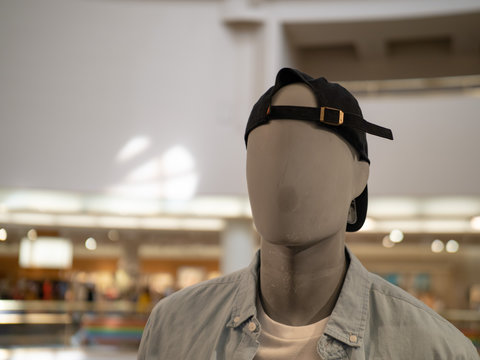 Male mannequin with backwards baseball cap in a department store