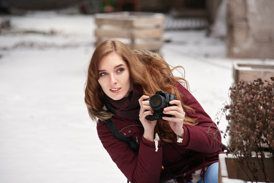 Portrait of woman photographer taking photos in winter city