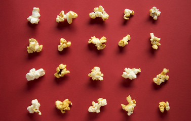 Popcorn is laid out in rows on a red background, the top view