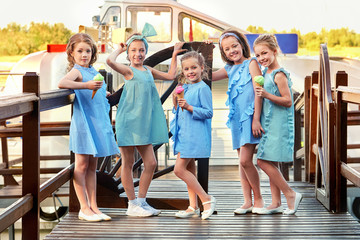 Group 5 five fashion lady kids in elegant striped dresses,marine style. Little girls in designer collection children's clothes. Girlfriends smile,standing on bridge. Vacation,fashionable concept.