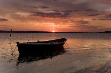 Fishing boat against orange sunset