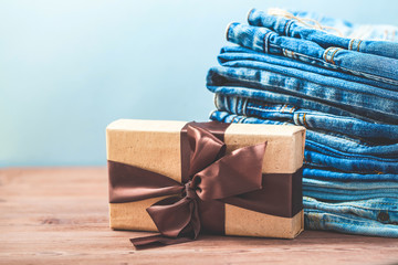 blue jeans with a gift on a wooden background Copy Space Place for text.