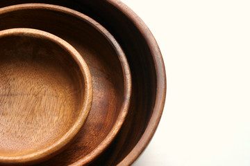 Three wooden empty bowls for eating, cooking salad stacked on top of each other on white background