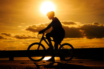 Silhouette woman ride bicycle silhouette in sunset