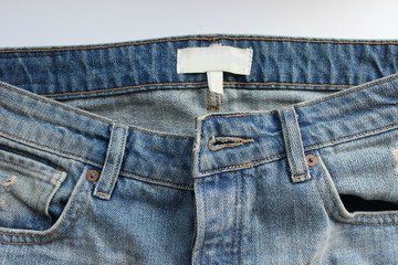 Details on denim pants, pocket and metal buttons, close-up. Free space for text