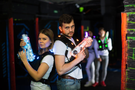 Two laser tag players standing back to back