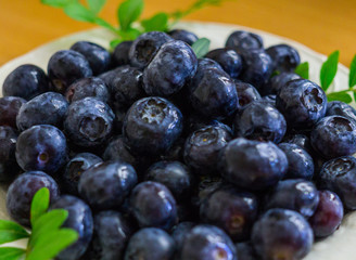 A garden blueberry poured in a saucer on a table