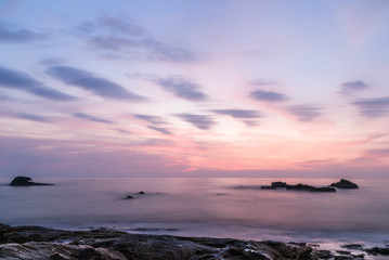 Colorful Sunset Soft Light on the Beach with Rocks,  Clouds and Blue Sky