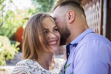 Obraz premium Young man whispering to woman or girlfriend, boyfriend telling surprising secret to his girl, man says nice words to his girlfriend, girl is smiling or laughing