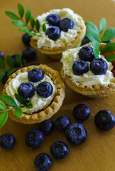 Sandwich baskets with whipped cream, decorated with blueberries on a table