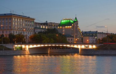 Bridge and building with a green roof in the evening. Russia, Moscow, June 2018