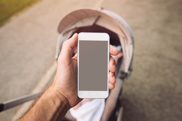 Phone is more interesting than baby in the stroller