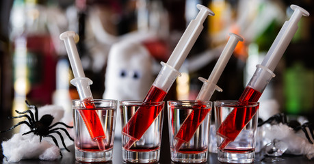 creepy halloween party cocktails with syringes of grenadine syrup as blood, shot drinks at party - obrazy, fototapety, plakaty