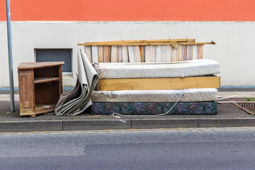 old mattresses, furniture and household items on the roadside