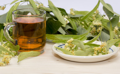 Linden tea in a glass cup blossoms and linden leaves