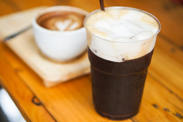 Beautiful Iced Americano or black coffee with foam form fresh coffee beans. on wooden bar.