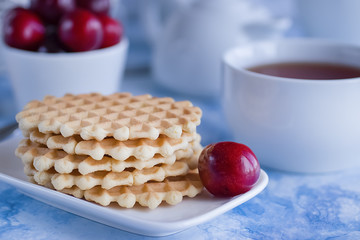 Breakfast. Fika. White cup of tea with thin waffles and lemon jam.