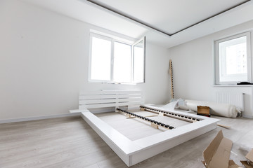 Assembling wooden bed in room