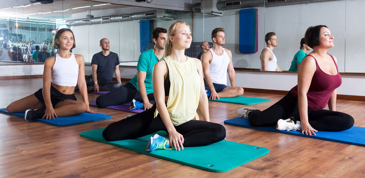 Adults having yoga class in sport club