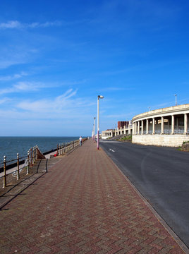 the long pedestrian walkway at the top of the north promenade in blackpool showing the seating and shelters along the coastline and deep blue sea