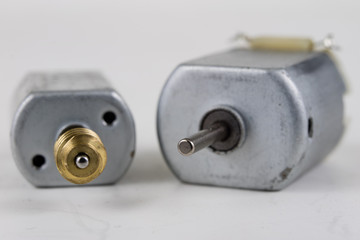 Small electric motor on a white workshop table. Electric drive used in small electrical devices.