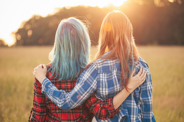 Two young women standing on the background of sunset. Best friends