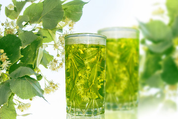 Lime glass of hot tea. Floral background.