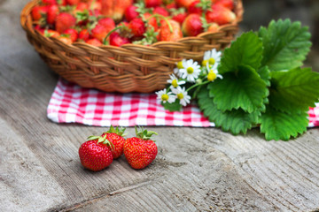 three strawberries on a wooden table on a Sunny day