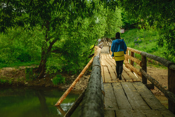 Girl on wooden bridge across river in Russia