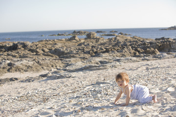 Baby crawling on beach, Galicia, Spain