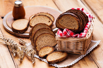 Sliced rye bread in a wicker basket and tablecloth 